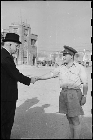 Prime Minister Peter Fraser greeted by Captain Edmund Webber at an airport near Naples, Italy, World War II - Photograph taken by George Bull