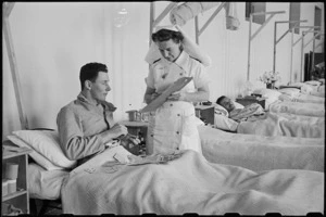 Sister V O'Brien marking patient's chart for J J Nicholson at 1 NZ General Hospital, Molfetta, Italy, World War II - Photograph taken by George Bull