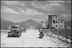 Vehicles travelling along Road 6 pass the ruins of Cassino Cathedral, Italy, World War II - Photograph taken by George Kaye