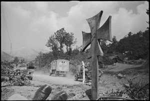 Vehicles pass enemy grave on their way forward on Cassino Front, Italy, World War II - Photograph taken by George Kaye