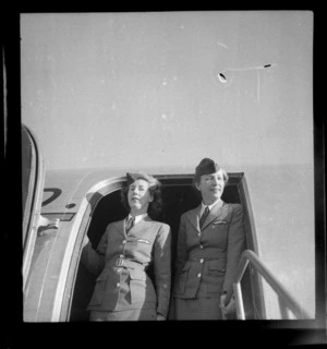 [Miss?] Helen Somerville (left) and [Miss?] Pat Manton, stewardesses for ANA (Australian National Airways), standing in front of doorway of passenger aircraft Douglas DC-4 Skymaster Amana