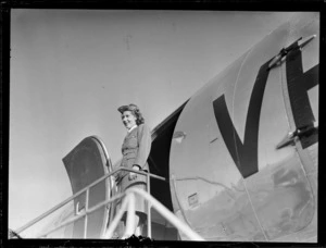 [Miss?] Helen Somerville, stewardess for ANA (Australian National Airways), standing in front of doorway of passenger aircraft Douglas DC-4 Skymaster Amana