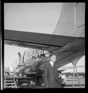 Unidentified man, representative from the Melbourne Age newspaper, next to passenger aircraft Douglas DC-4 Skymaster Amana