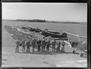 Group portrait of unidentified Auckland Aero Club members in front of Tiger Moths and Rearwin Beechcraft aeroplanes, Mangere Airfield, Auckland