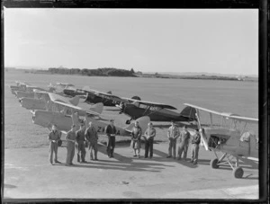 Group portrait of unidentified Auckland Aero Club members in front of Tiger Moths and Rearwin Beechcraft aeroplanes, Mangere Airfield, Auckland