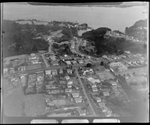 Birkenhead and Mokoia Road in mid-view with residential housing, and the Chelsea Refinery Plant with Chelsea Bay beyond, looking to Auckland City