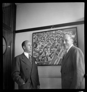 Jack Bisco, left, (United Press) New York and Phil Curran (United Press) Sydney, standing in front of a Whites Aviation photograph hanging on the wall