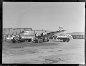 Vacuum Oil 'Intrava' truck and trailer, with a Pan American Airways Clipper aircraft, Whenuapai airfield, Auckland