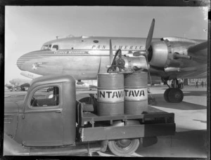 Vacuum Oil 'Intrava' truck, with barrels, including a Pan American Airways Clipper Mandarin aircraft, Whenuapai airfield, Auckland