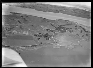 View of the Kellihers' Puketutu Island farm with fenced pastures and homestead with trees looking to Manukau Airfield, Manukau Harbour, South Auckland