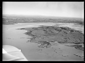 View of the Kellihers' Puketutu Island farm with road access causeway, looking to Mangere and Manukau City beyond, Manukau Harbour, South Auckland