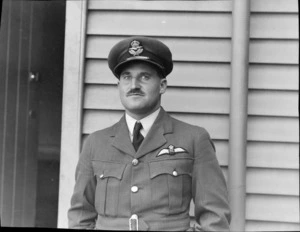 Portrait of Wing Commander Theo de Lance in RNZAF uniform, DFC, in front of an unidentified building, Auckland