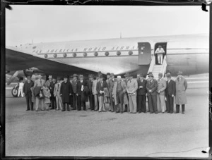 View of Pan American Airways Good Will Flights No1 of Clipper Class Kathay DC4 passenger plane, with an unidentified group of men in front, Whenuapai Airfield, Auckland