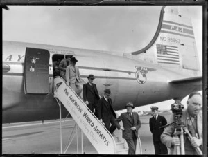 View of unidentified passengers disembarking from a Pan American Airways Clipper Class Cathay DC4 passenger plane Good Will Flight, Whenuapai Airfield, Auckland