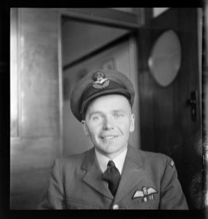 Portrait of Flight Lieutenant A W B Hayman RNZAF, in uniform, of the Instrument School Whenuapai, at Whites Aviation Office, Auckland