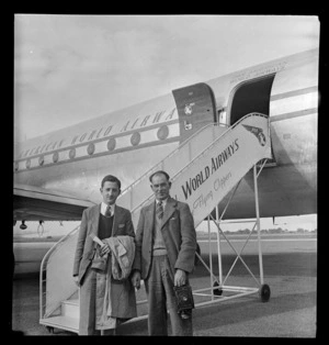 Portrait of (L to R) Ted Beckett and Bert Snowden with camera disembarking from a Pan American Airways Clipper Class Cathay DC4 passenger plane Good Will Flight, Whenuapai Airfield, Auckland