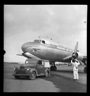 Pan American World Airways Clipper Kathay aircraft, on tarmac, being directed by member of groundcrew, RNZAF Station, Whenuapai, Auckland