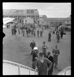 View of unidentified people boarding Pan American Airways Clipper Class Cathay DC4 Good Will Flight passenger plane at Whenuapai Airfield, Auckland