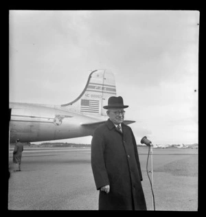 Portrait of J A C Allum, Mayor of Auckland, in front of Pan American Airways Clipper Class Cathay DC4 Good Will Flight passenger plane, Whenuapai Airfield, Auckland