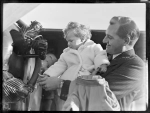 Mr K Davies, holding a small child, at Auckland Aero Club