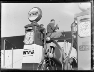 Auckland Aero Club, Mangere, Auckland, showing an unidentified man refuelling an aircraft from a Intava fuel pump