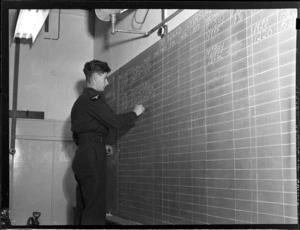 Flying Control Room, Mechanics Bay, Auckland, showing an unidentified man chalking on the blackboard