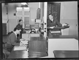 Flying Control Room, Mechanics Bay, Auckland, showing two unidentified men working alongside each other, with the woman on the phone