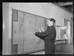 Flying Control Room, Mechanics Bay, Auckland, showing an unidentified man working on a wall chart