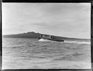 Flying Control Room, Mechanics Bay, Auckland, showing an unidentified man on the boat [Tanden?] going out to sea, with Rangitoto Island in the background