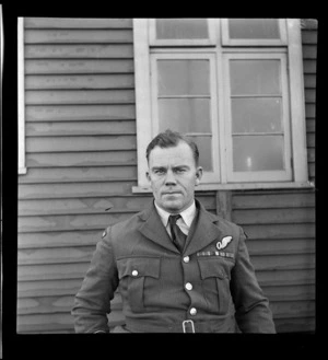 Portrait of Flight Lieutenant T K Patterson in uniform of Sutherland Flights in front of a building at Mechanic's Bay, Auckland Harbour