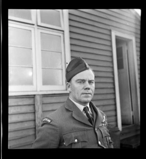 Portrait of Flight Lieutenant T K Patterson in uniform of Sutherland Flights in front of a building at Mechanic's Bay, Auckland Harbour