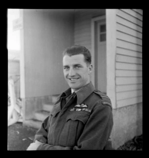 Portrait of Flight Lieutenant G R Coates RNZAF in uniform in front of an unknown building, Auckland City