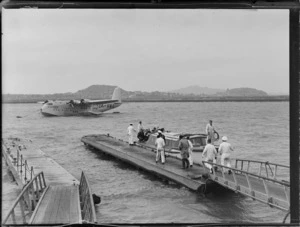View of the arrival of unidentified passengers and crew on a launch off TEAL Short Tasman Flying Boat ZK-AMA 'Australia' at Mechanic's Bay, Auckland City