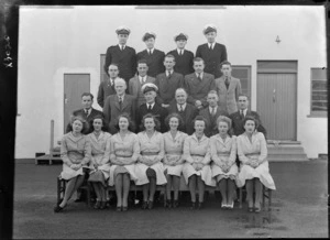 Group portrait of G N Roberts and unidentified TEAL Administrational Staff including pilots in uniform outside a building at Mechanic's Bay, Auckland City