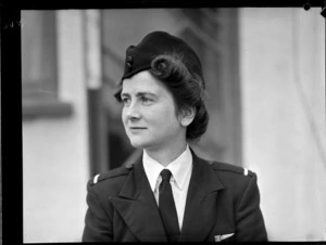Portrait of Miss B P Morton TEAL Stewardess in uniform outside an unidentified building, [Auckland?]