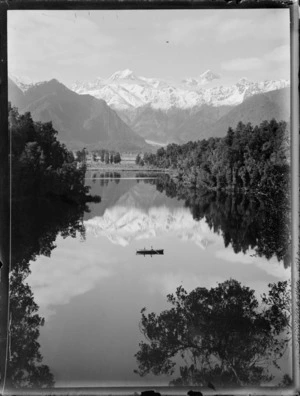 Lake Matheson, showing Mt Cook and the Tasman glacier, South Westland, includes two people in a dinghy