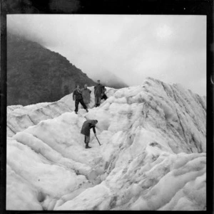 Unidentified group of people at Fox Glacier, South Westland, including a man with an ice pick