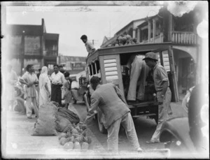 Outdoor market, Suva, Fiji, showing men unloading pineapples from a truck