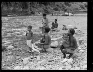 View of local Bougainville Island woman and children beside a large mountain river, North Solomon Island group