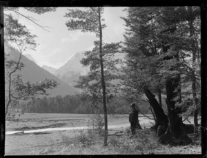 View of the Eglinton Valley and river with an unidentified man looking to snow covered mountains beyond, Fiordland National Park, Southland Region