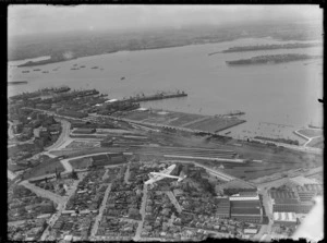 View of the Short S23 Empire Flying Boat Centaurus G-ADUT flying over Parnell and Auckland Railway Station with Auckland City and Harbour beyond