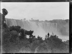 View of an unidentified man looking at Wairua Falls, Northland