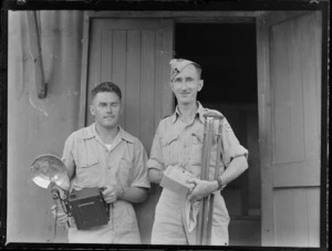 Portrait of Flight Sergeant Ron Tompkins, (on the left) holding a camera with a flashbulb, with Reg Price at St Lauthala Bay, Fiji