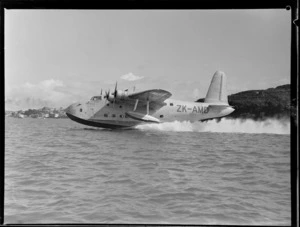 Side view of the TEAL Short Tasman Flying Boat ZK-AMD Clipper 'Australia' taking off [from Auckland?]