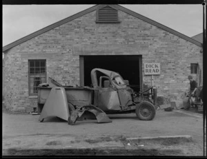 Premises of Dick Read, Panel Beater, Devonport, North Shore, Auckland, includes an unidentified man and a damaged truck