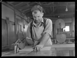 Portrait of an unidentified man using a circular saw within a workshop, the Blind Institute Building, [Auckland?]