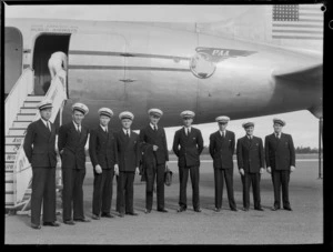 Group portrait of unidentified Pan American Airways pilots standing in front of a PAA Clipper Class aeroplane, Whenuapai Airfield, Auckland