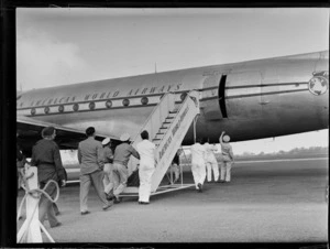 Unidentified staff members pushing the gangway up to Pan American World Airways (PAWA) clipper aircraft, 'Malay' at Whenuapai Airbase, Auckland