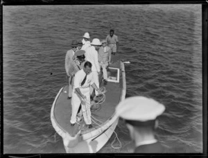 View of a group of unidentified civil and military men on a small launch about to board the TEAL Short S30 Empire Class flying boat 'Aotearoa' ZK-AMA, Suva, Fiji