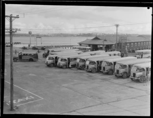 Wakefield Oil Company, with a view of Devonport Wharf and the North Shore Transport Co Ltd bus station with passengers boarding, Auckland City